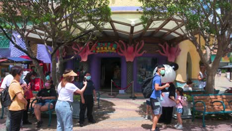 Visitors-take-photos-with-a-park-employee-dressed-in-a-panda-costume-at-Ocean-Park