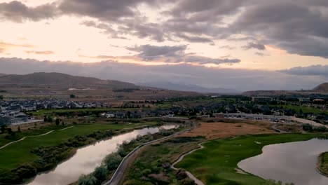 Stunning-sunset-aerial-hyperlapse-of-an-idyllic-community-along-a-river-and-golf-course
