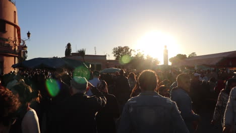 Large-crowds-roaming-the-streets-of-Marrakech-Morocco-with-sun-flare-in-background