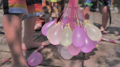 Statische-Slomo-Aufnahme-Von-Bunten-Wasserballons,-Die-An-Einem-Sonnigen-Tag-Gefüllt-Werden
