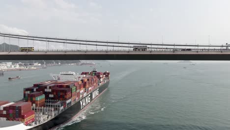 Mega-Container-ship-approaching-Hong-Kong-port-and-Stonecutters-bridge,-Aerial-view