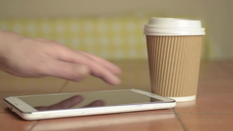 Hands-holding-a-takeaway-coffee-to-go-with-tablet-medium-shot