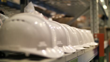 Row-of-new-safety-helmets-on-shop,-warehouse-shelf,-construction-site-essentials