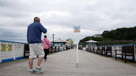 Llandudno-seaside-resort-town-pier-tourist-looking-at-corona-virus-social-distancing-on-boardwalk