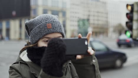 Mädchen,-Das-Panoramafoto-Mit-Smartphone-Auf-Der-Straße-Neben-Einer-Stark-Befahrenen-Straße-In-Der-Stadt-Macht