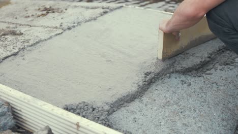 working-freshly-poured-concrete-tapping-with-wooden-board