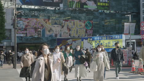 Jóvenes-Japonesas-Caminando-Por-El-Famoso-Cruce-De-Shibuya-Con-Luz-De-Señal-De-Fondo-En-Tokio,-Japón