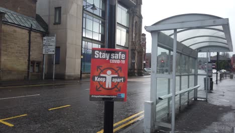 A-close-up-of-the-covid-sign-next-to-a-bus-stop-during-the-Tier-4-lockdown-in-Scotland