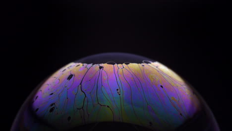 Close-Up-Footage-Of-Colorful-Iris-Of-Soap-Bubble-In-Black-Background