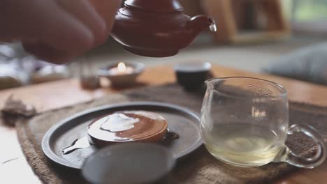 Slow-motion-tea-ceremony-pouring-tea-into-a-glass-pitcher