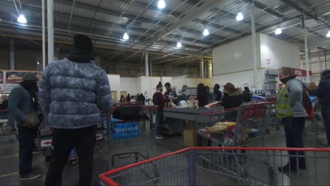 Customers-Queuing-In-Line-For-Checkout-With-Their-Shopping-Trolley-At-Costco