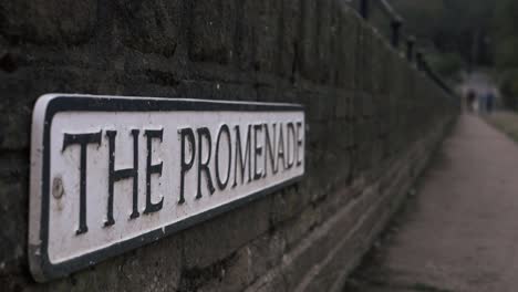 Promenade-street-sign-on-a-wall-medium-panning-shot