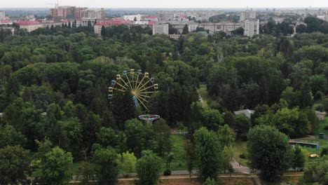 Aerial-View-of-Ferris-Wheel-in-the-Middle-of-a-Park-Surrounded-by-Trees-in-Ukraine