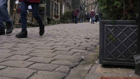 Shoppers-browsing-in-cobbled-street-in-Yorkshire-village-Haworth-low-shot