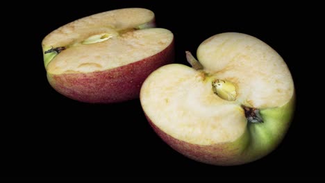 Nahaufnahme-Eines-Verrottenden-Frischen-Apfels-Auf-Schwarzer-Oberfläche,-Zeitraffer