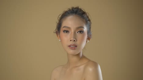 Schöne-Junge-Asiatin-Posiert-Für-Glamour-Headshots-In-Einem-Professionellen-Mode-Shooting-Mit-Beigem-Hintergrund