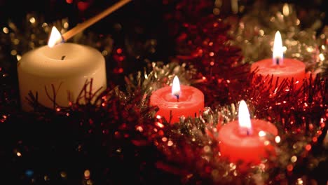 Beautiful-video-of-hand-lighting-candles-with-sparkling-backgrounds-made-of-Christmas-decoration