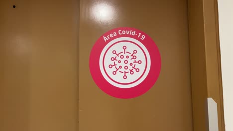 COVID-Area-red-warning-sticker-close-up-in-Elevator-door-in-Clinic---Hospital---Latin-America