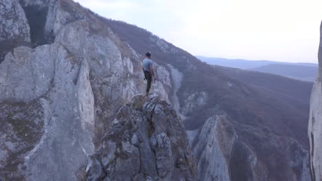 Aufsteigende-Luftaufnahme-Der-Gipfel-In-Der-Turda-Schlucht,-Rumänien,-Zeigt-Den-Kletterer-Oben-Auf-Einem-Kleinen-Felsigen-Gipfel-Mit-Blick-Auf-Das-Unglaubliche-Gelände-Und-Die-Landschaft-Der-Berge-Und-Schlucht