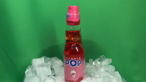 3-3-Best-Selling-Japanese-Carbonated-Strawberry-Flavor-drink-called-Marble-Pop-ball-activated-carbonation-under-lid-to-preserve-the-rich-taste-rotating-360-degrees-in-ice-pile-in-front-of-green-screen