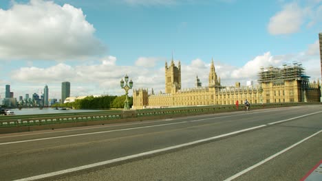 Lockdown-in-London,-cyclists-ride-across-empty-Westminster-Bridge-with-the-Houses-of-Parliament-in-the-background,-during-the-Coronavirus-pandemic-2020
