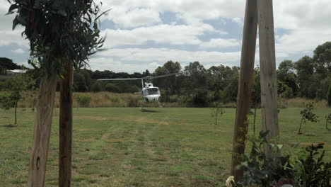 Hubschrauber-Landet-Auf-Einem-Feld,-Das-Durch-Eine-Hochzeitslaube-Betrachtet-Wird,-Zeitlupe