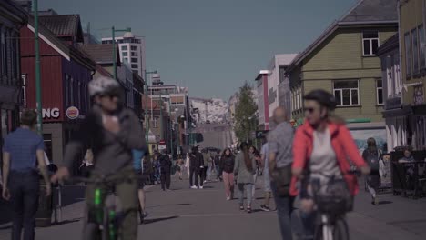 Gente-Caminando-Y-Andando-En-Bicicleta-En-La-Calle-Principal-Storgata-En-Tromso,-Noruega---Plano-Medio