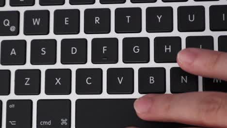 Hand-Presses-Letter-Buttons-On-Modern-Laptop-Keyboard,-close-up,-overhead-shot