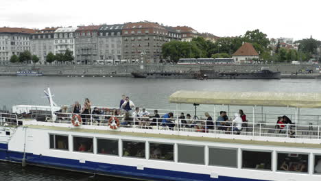 Leute,-Die-Spaß-Auf-Dem-Dach-Eines-Sightseeing-Bootes-Haben,-Vltava,-Prag,-Tschechien