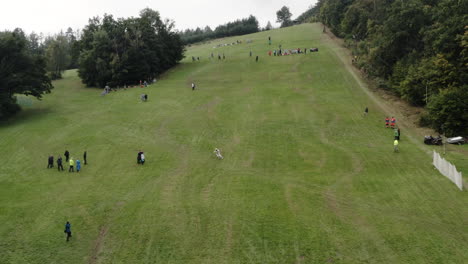 Aerial-Shot-Of-Person-Skiing-In-Downhill-Grass-Ski-Competition,-Alpine-Mountain-Landscape-In-Summer