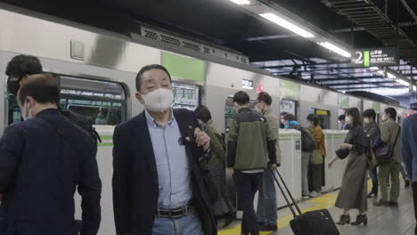 Menschen-Mit-Schutzmasken-Steigen-Während-Der-Weltweiten-Pandemie-In-Tokio,-Japan,-In-Den-Zug-Der-Yamanote-linie-Ein-Und-Aus