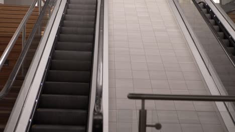 Escalator-in-empty-shopping-center-mall-wide-panning-shot