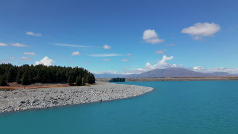Cars-crossing-stunning-blue-lake-Pukaki-in-New-Zealand