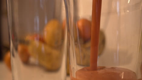 Close-up-of-an-healthy-tropical-fruit-juice-that-pours-into-glass