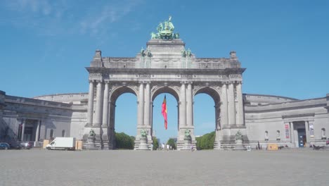 Still-static-shot-of-the-Cinquantennaire-triumphal-arc-monument-in-Brussels,-Belgium,-on-warm-sunny-summer-day-with-blue-skies,-with-construction-crane-above-the-monument-in-distance