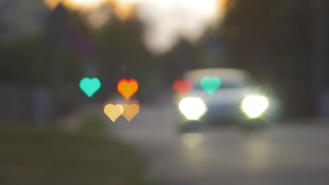 Beautiful-hearts-bokeh-from-moving-car-and-traffic-lights-at-the-evening,-Valentines-Day-or-social-media-Like-background-concept
