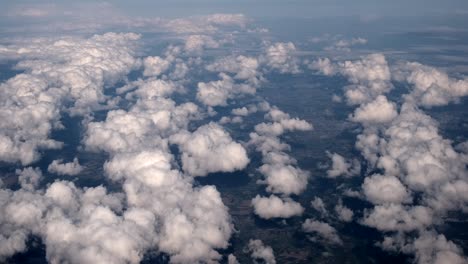 aerial-footage-shot-from-high-altitude-plane-with-clouds-spotted-throughout-as-weather-meteorological-example