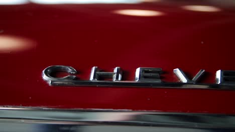 Off-hand-dolly-shot-of-a-Chevelle-logo-on-hood-of-a-red-chevy
