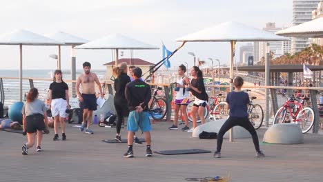 Gente-Entrenando-En-El-Gimnasio-Al-Aire-Libre-Cerca-Del-Mar-Y-Cerca-De-La-Playa-En-Tel-Aviv,-Israel