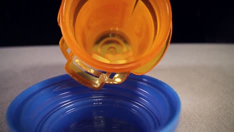 Schnelles-Herausziehen-Der-Gesamten-Länge-Einer-Orangefarbenen-Flasche-Für-Verschreibungspflichtige-Pillen,-Wodurch-Eine-Leere-Blaue-Flaschenkappe-Freigelegt-Wird