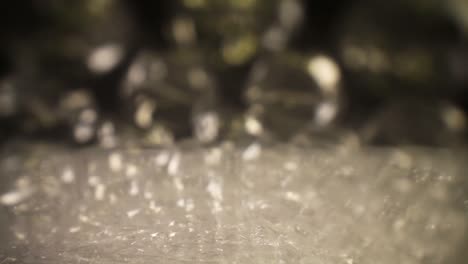 pushing-into-a-bubble-wrap-bag,-where-the-bag-is-really-close-to-the-lens-as-it-cascades---rolls-away-as-it-moves-through