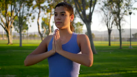 Una-Hermosa-Joven-Hispana-Yogui-Meditando-En-Una-Pose-De-Manos-De-Oración-De-Una-Pierna-En-El-Parque-Al-Amanecer