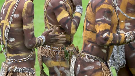Bemalte-Stammes-Tänzer-In-Muscheldekoration-Reiben-Stäbchen-In-Den-Händen,-Neuguinea