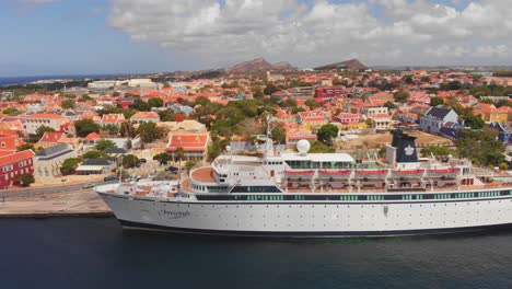 Panning-aerial-of-a-cruise-ship-and-the-neighbourhood-of-Otrobanda-in-Willemstad,-Curacao