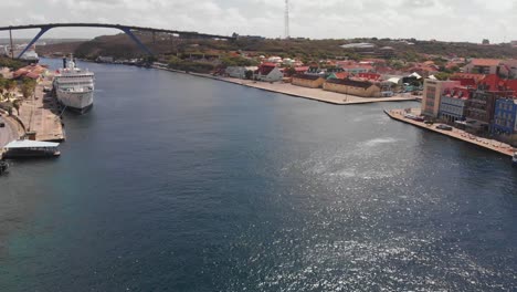 Drone-footage-of-a-cruise-ship-docked-in-Sint-Anna-Bay-Willemstad,-Curacao