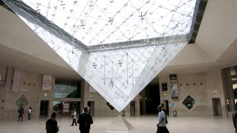 Wide-tilt-footage-from-bottom-to-the-top-of-the-inverted-glass-pyramid-inside-the-main-hall-of-the-Louvre-museum,-Paris,-France