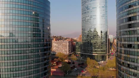Flying-backwards-between-two-buildings-revealing-the-skyline,-Santiago,-Chile-4K