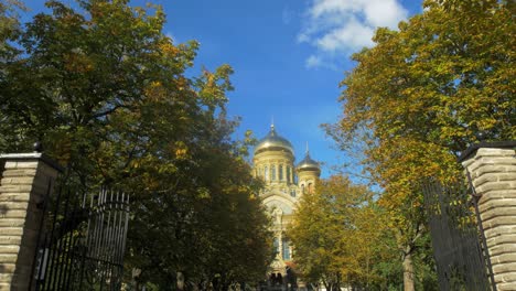 View-of-orthodox-St-Nicholas-Naval-Cathedral-golden-domes-and-crosses-on-blue-sky-in-sunny-autumn-day-at-Karosta,-Liepaja,-tilt-up-wide-shot