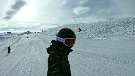A-kid-snowboarding-holing-a-selfie-stick