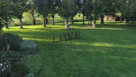 Liebeszeichen-Aus-Pflanzen-Für-Romantische-Veranstaltungen-Bei-Sonnenuntergang-Mit-Bäumen-Im-Hintergrund